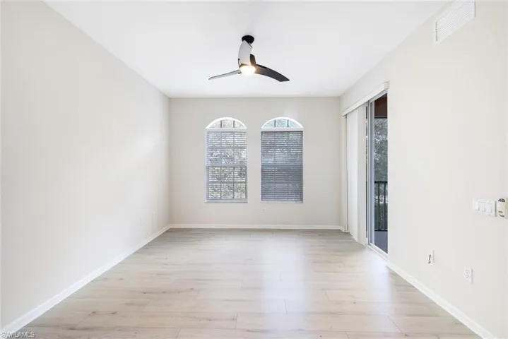 Empty room with ceiling fan and light hardwood / wood-style flooring