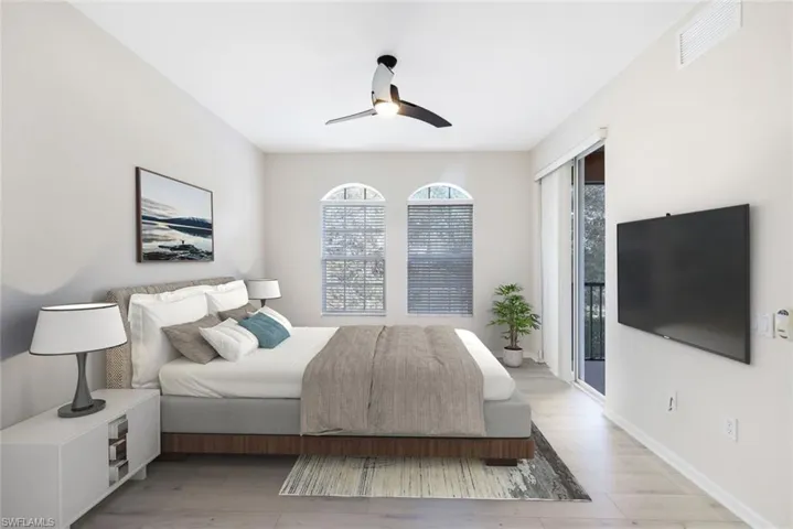 Bedroom with access to exterior, light wood-type flooring, multiple windows, and ceiling fan