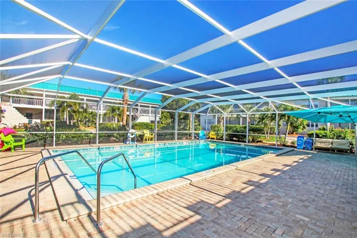 View of pool with glass enclosure and a patio