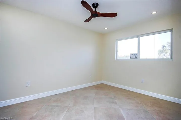 Tiled spare room with ceiling fan