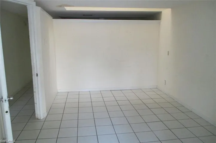 Empty room with light tile patterned flooring