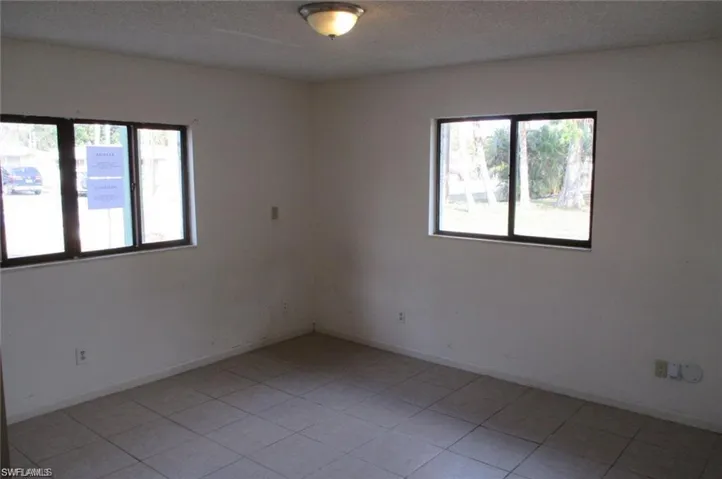 Unfurnished room with light tile patterned flooring and a textured ceiling