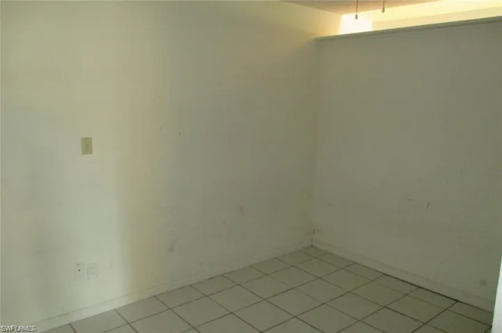 Empty room with baseboards and light tile patterned floors