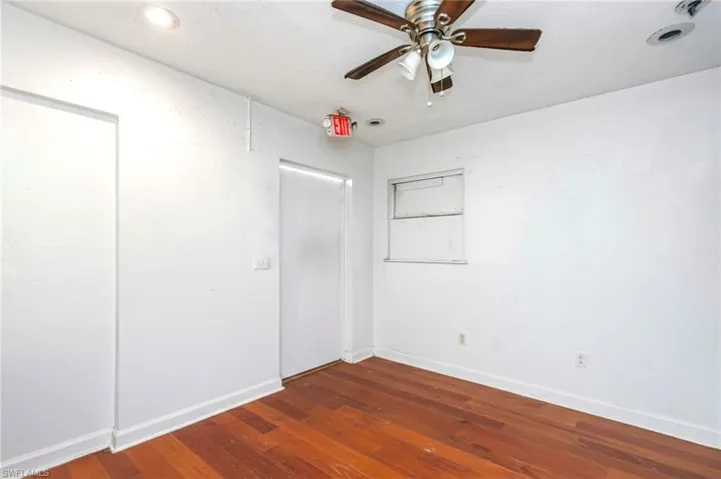 Unfurnished bedroom with dark wood-style floors and ceiling fan