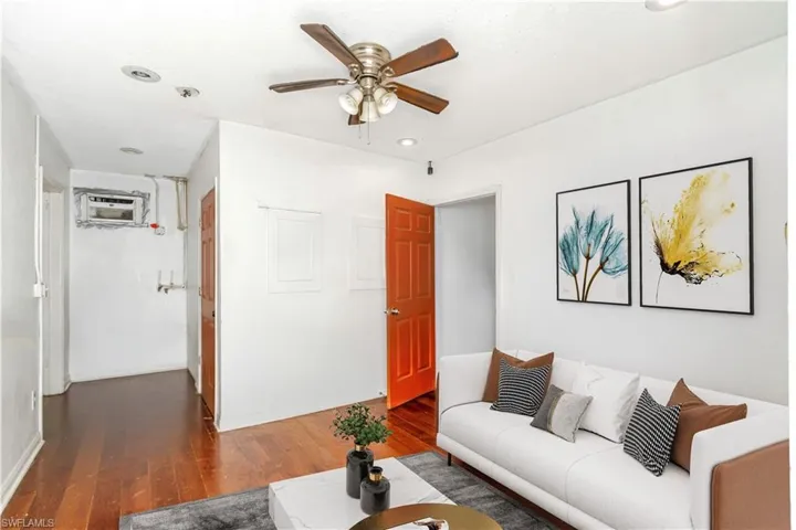 Living room with wood-type flooring, a ceiling fan, and recessed lighting