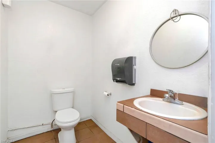 Half bath with tile patterned flooring and vanity