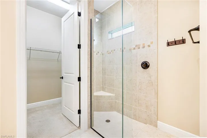 Primary Bathroom featuring a walk-in shower and a spacious closet