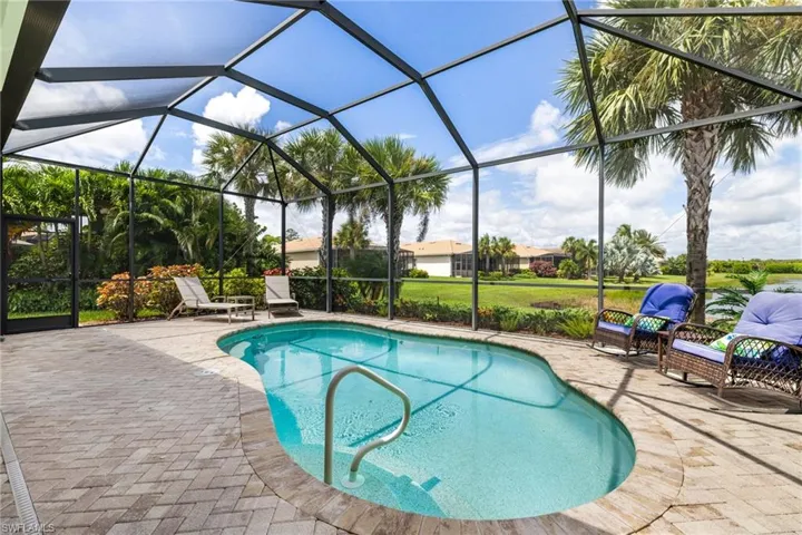 Lakeside pool with seating areas, privacy landscaping, and lake views.