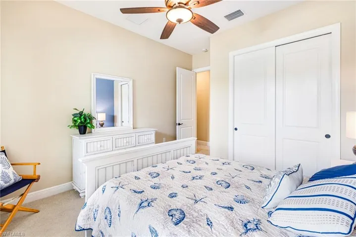 Guest Bedroom with light carpet, neutral colors, a ceiling fan, and a closet