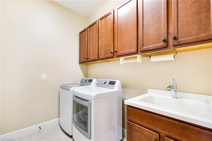 Laundry room featuring separate washer and dryer, Laundry Sink, and cabinet space