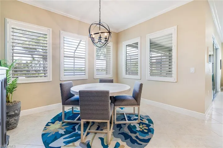 Dining space looking out onto Lanai and Lake. Plantation shutters, chandelier.
