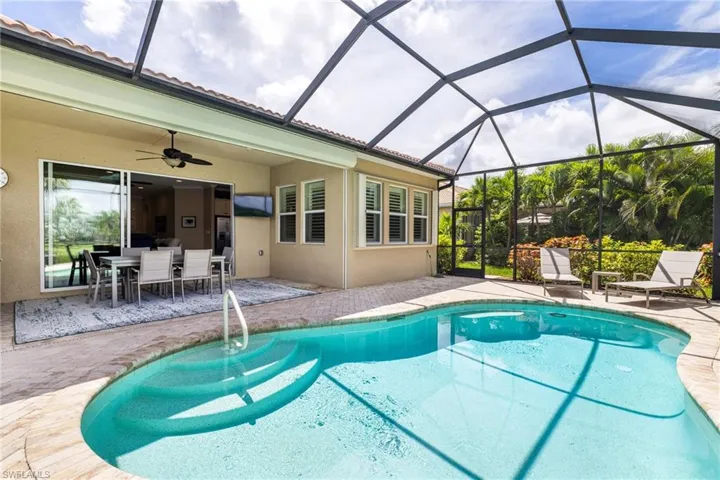 Outdoor pool with deck area, a ceiling fan, outdoor dining space, lanai area.