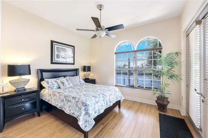 Bedroom featuring ceiling fan, baseboards, and light wood-style flooring