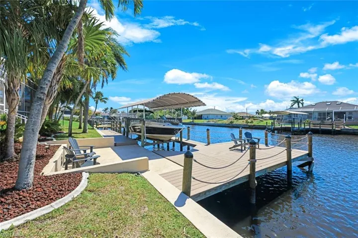 Dock area featuring a lawn, a water view, and boat lift