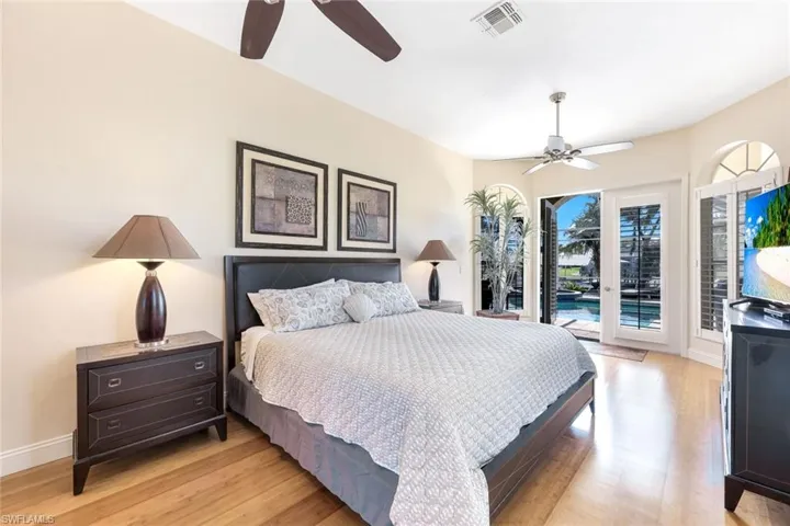 Bedroom featuring access to exterior, visible vents, baseboards, light wood-style floors, and a ceiling fan