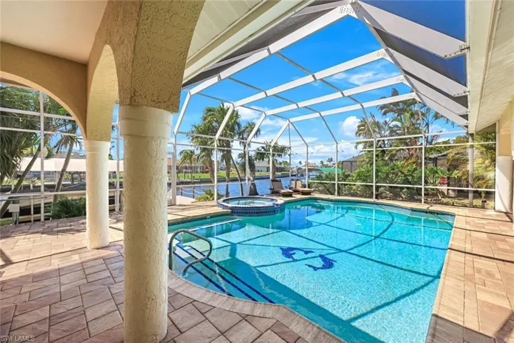 View of swimming pool featuring a patio, a lanai, and a pool with connected hot tub