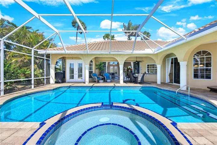View of pool with a patio area, french doors, and a pool with connected hot tub