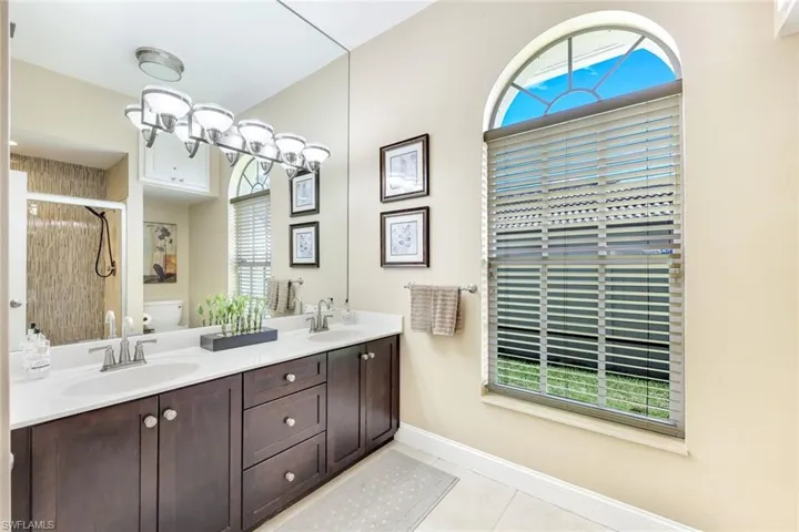 Full bathroom featuring a sink, toilet, a stall shower, and tile patterned flooring