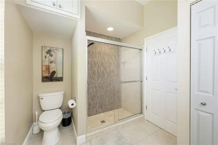 Bathroom with tile patterned floors, a shower stall, toilet, and baseboards
