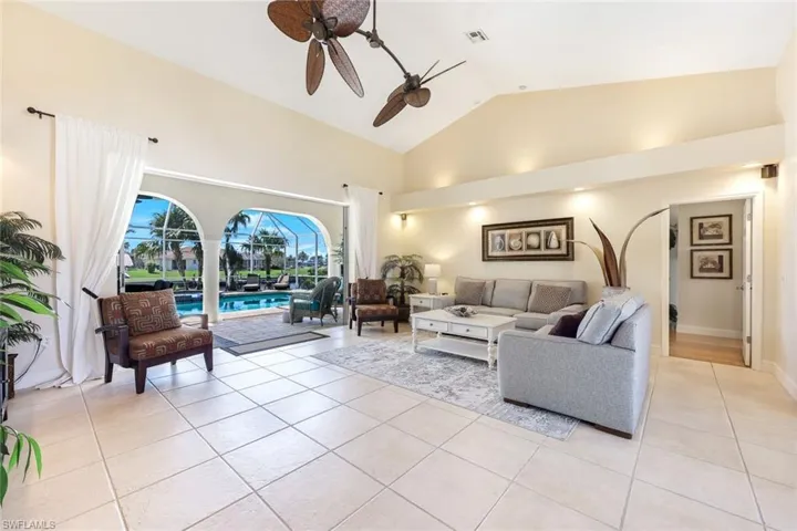 Living area featuring light tile patterned floors, visible vents, high vaulted ceiling, and ceiling fan