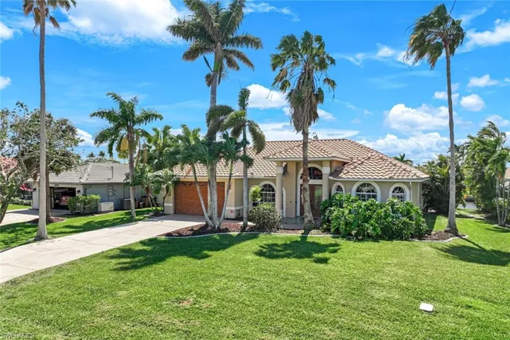 Mediterranean / spanish house featuring a front yard, driveway, stucco siding, a garage, and a tile roof
