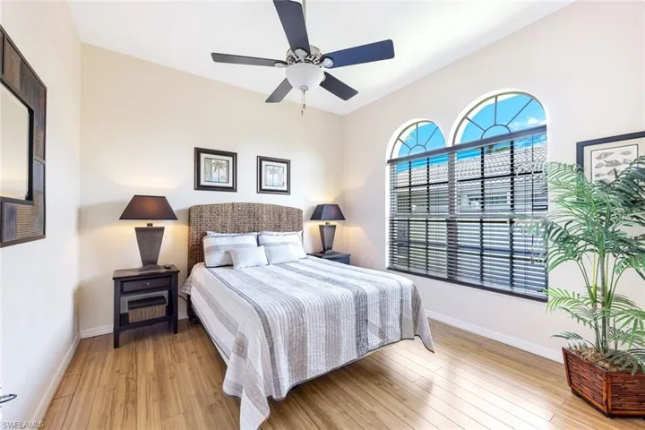 Bedroom with light wood-style flooring, a ceiling fan, and baseboards