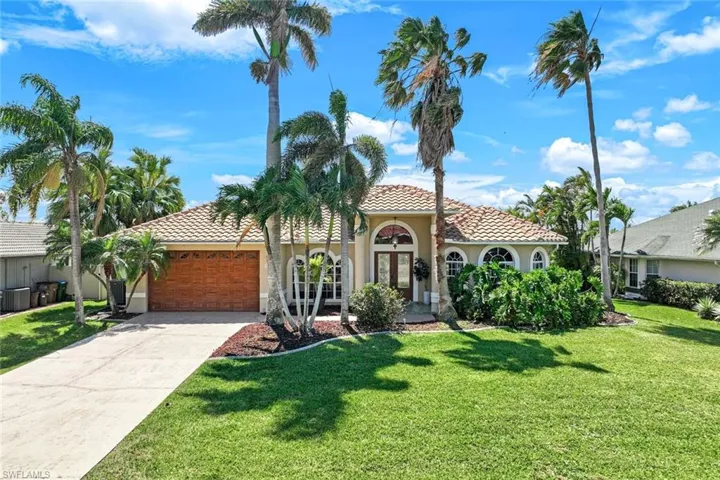 Mediterranean / spanish home with a front yard, stucco siding, concrete driveway, a garage, and a tile roof