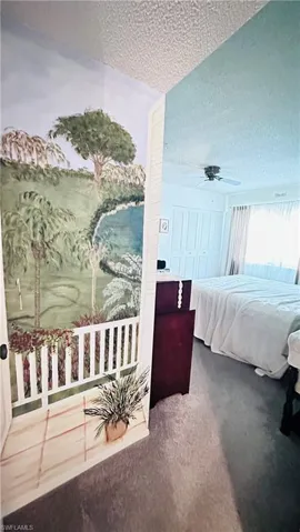 Bedroom featuring a textured ceiling, carpet floors, and ceiling fan