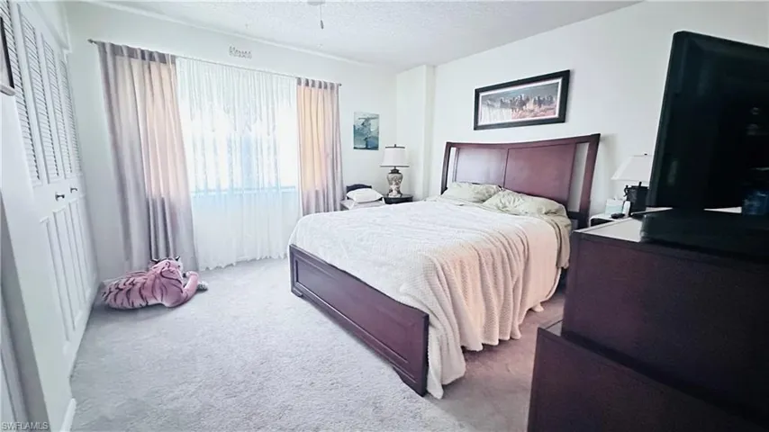 Carpeted bedroom with a textured ceiling