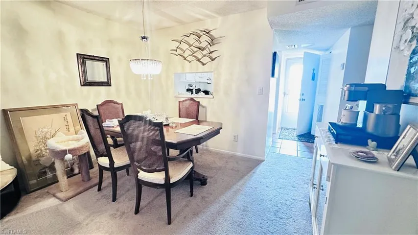 Dining area with carpet and a chandelier