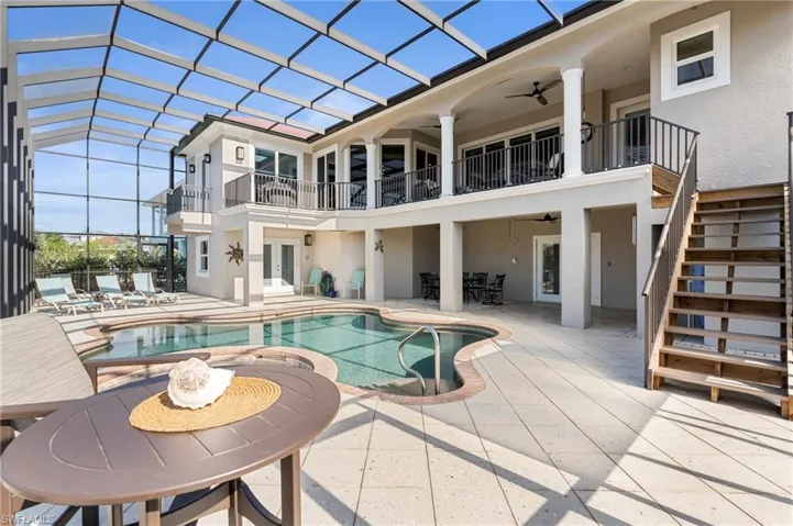 Rear view of house featuring ceiling fan, a lanai, and a patio