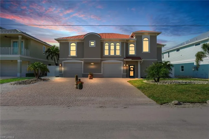 View of front of property featuring a garage and a lawn