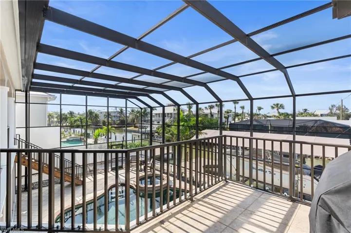 View from balcony of canal, neighborhood, a water view, enclosure, and a pool with hot tub