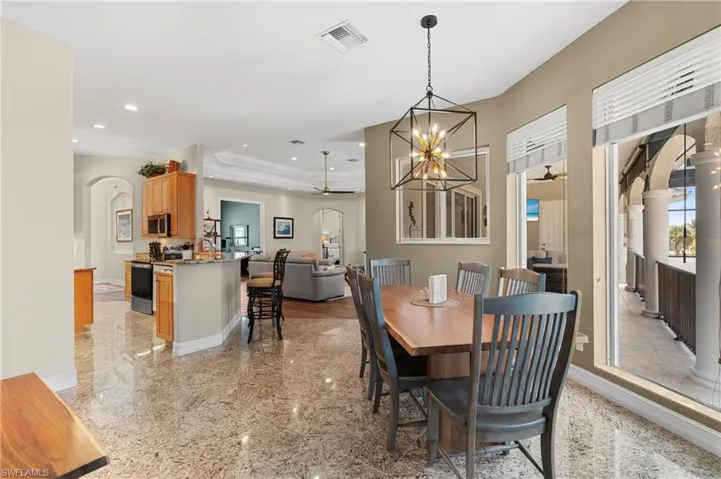 Dining room with crown molding and ceiling fan with notable chandelier