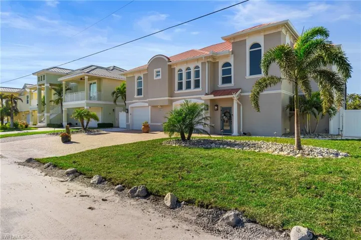 Mediterranean / spanish house with a garage and a front lawn