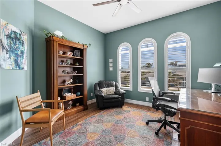 Office space with hardwood / wood-style flooring and ceiling fan