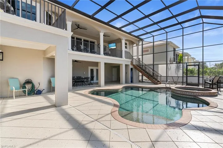 View of swimming pool featuring a lanai, a patio area, ceiling fan, and an in ground hot tub