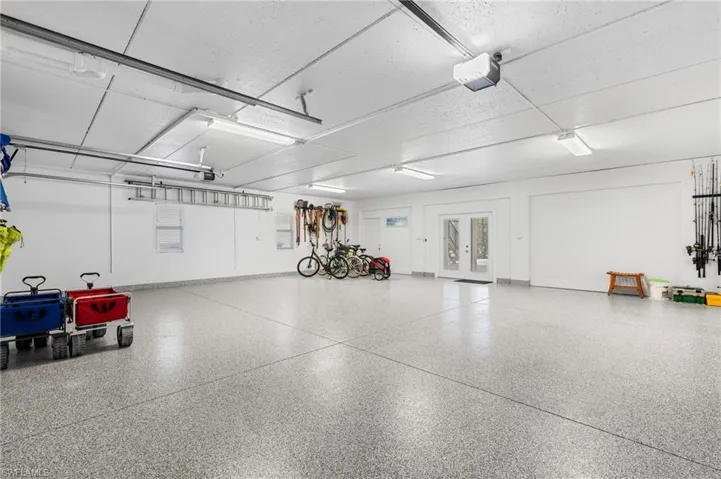 Garage featuring a garage door opener and french doors