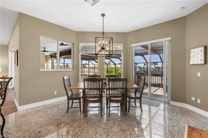 Dining space featuring ceiling fan with notable chandelier
