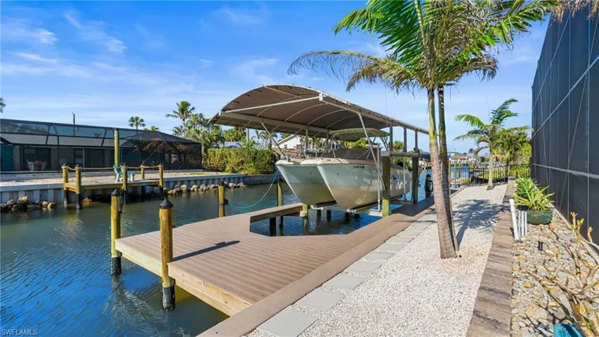 View of dock with a lanai and a water view