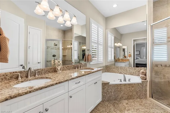 Bathroom with vanity, plenty of natural light, independent shower and bath, and a chandelier