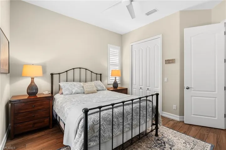 Bedroom with dark wood-type flooring, a closet, and ceiling fan