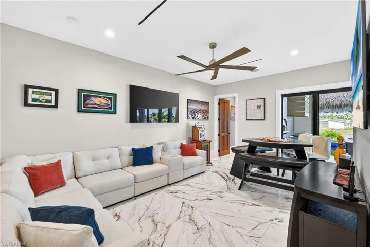 Living room with light marble finish floors, a ceiling fan, and recessed lighting