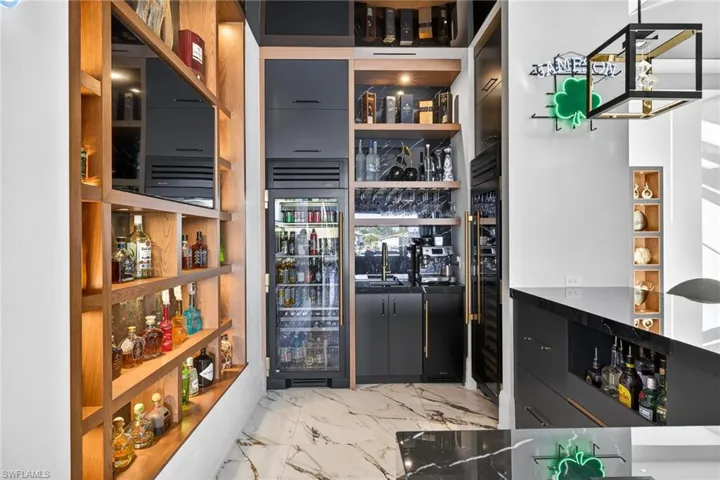 Storage area featuring wine cooler and a sink