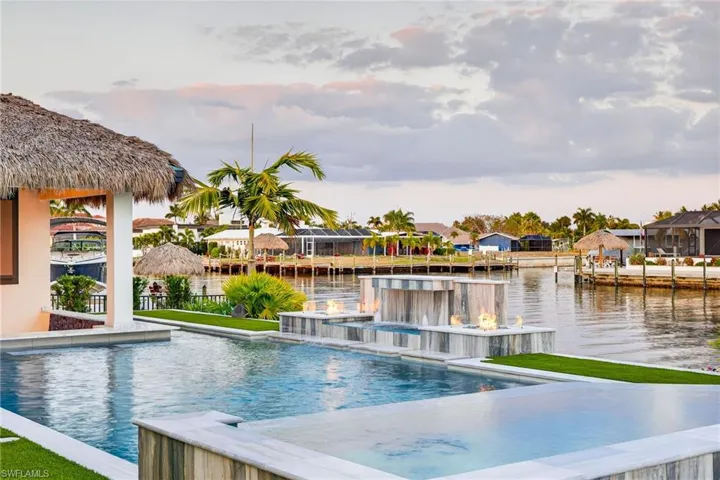 View of pool featuring an infinity pool, a water view, and patio surround