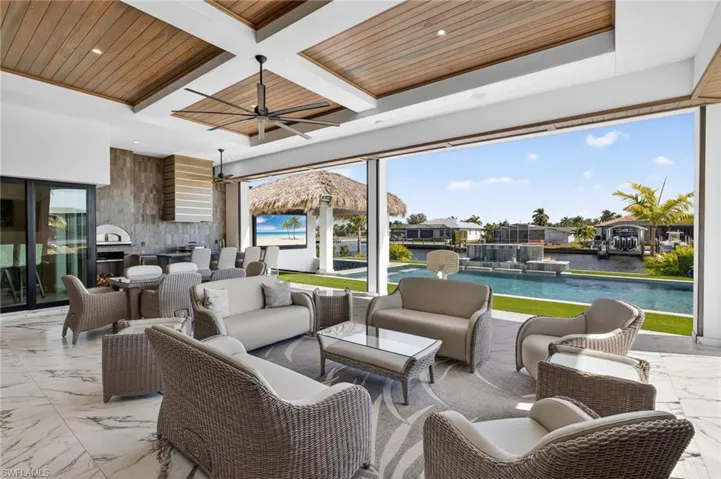 View of patio featuring an outdoor living space, ceiling fan, an outdoor pool, and grilling area