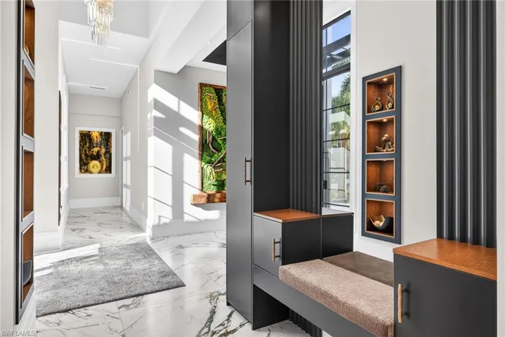 Foyer entrance with light marble finish floors and suspended lighting
