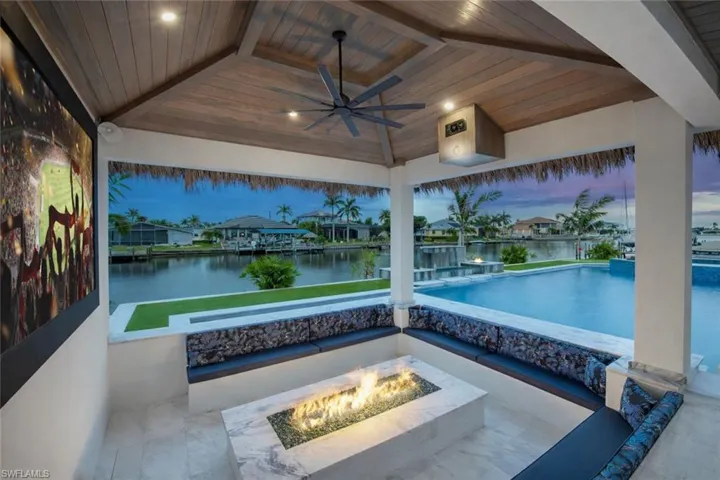 View of patio / terrace featuring a fire pit, ceiling fan, a water view, and a residential view