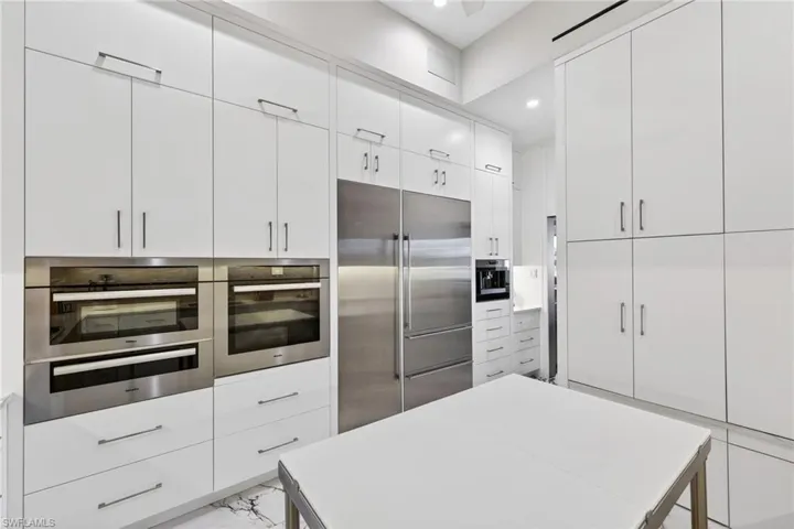 Kitchen with stainless steel appliances, white cabinetry, modern cabinets, recessed lighting, and light countertops