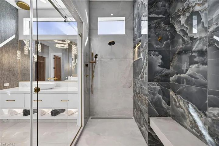 Full bathroom featuring vanity and a marble finish shower